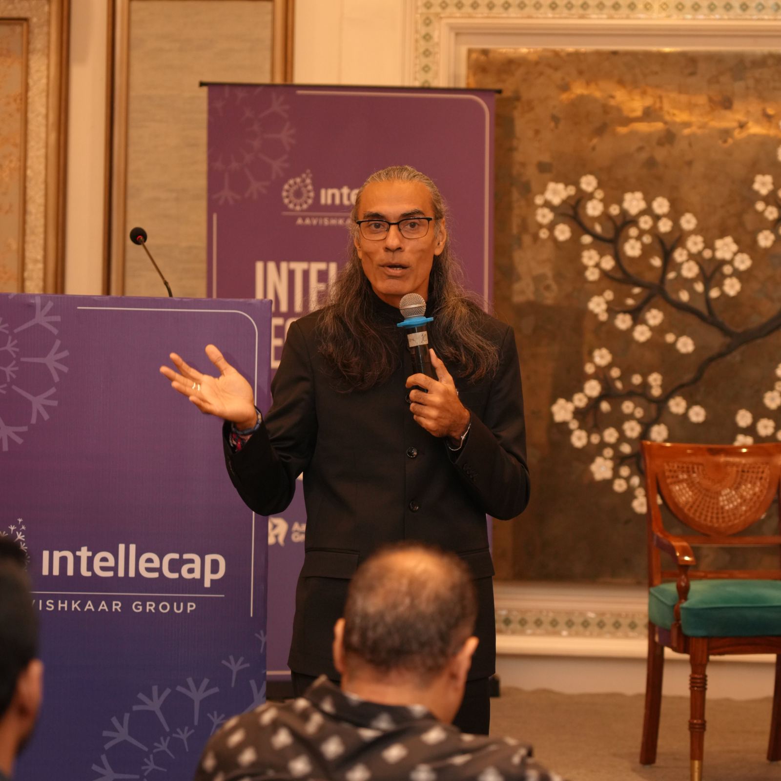 A speaker beneath the Intellecap Leadership Exchange banner, New Delhi