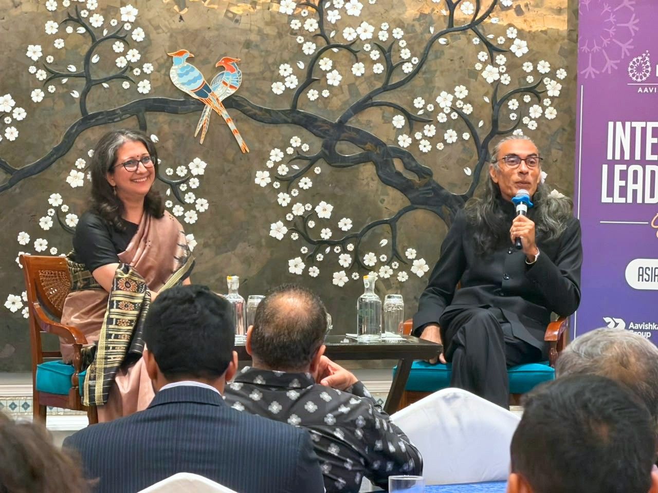 Fireside conversation beneath the Intellecap Leadership Exchange banner, New Delhi